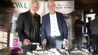 Dagelijks bestuurders Peter van Dijk (links op de foto) en Chrit Wolfhagen (rechts op de foto) snijden gezamenlijk de taarten aan