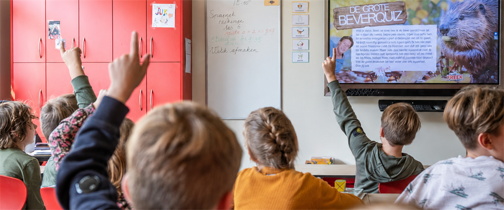 Kinderen steken hun vinger op tijdens een gastles