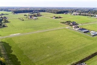 Omgeving met weilanden en huizen