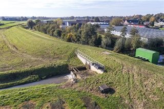 Omgeving met dijkverhoging en beek