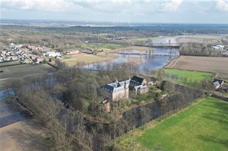 Omgeving met weilanden, water en huizen