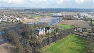 Omgeving met weilanden, water en huizen