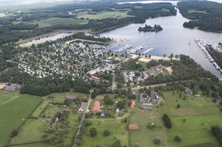 Luchtfoto met weilanden, water en huizen