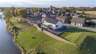 Water met huizen aan de dijk