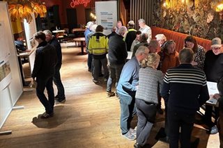 Bezoekers tijdens de inloopavond stellen vragen