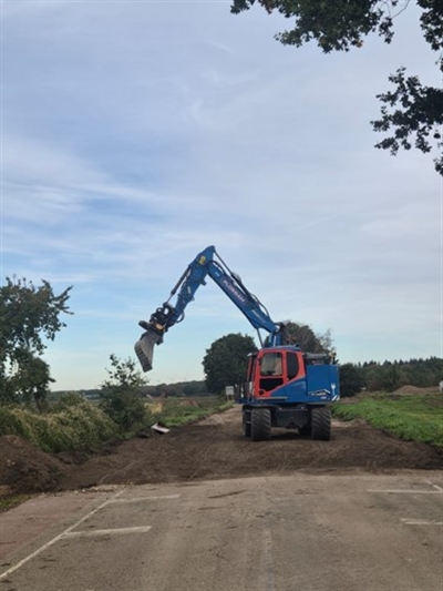 Foto van graafmachine bij dijkovergang Maasstraat